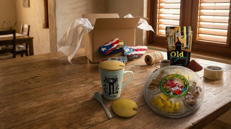 Caja de regalo con galletas en lata con forma de Puerto Rico, café Old San Juan, taza con tapa y bowl de dulces típicos sobre una mesa de madera