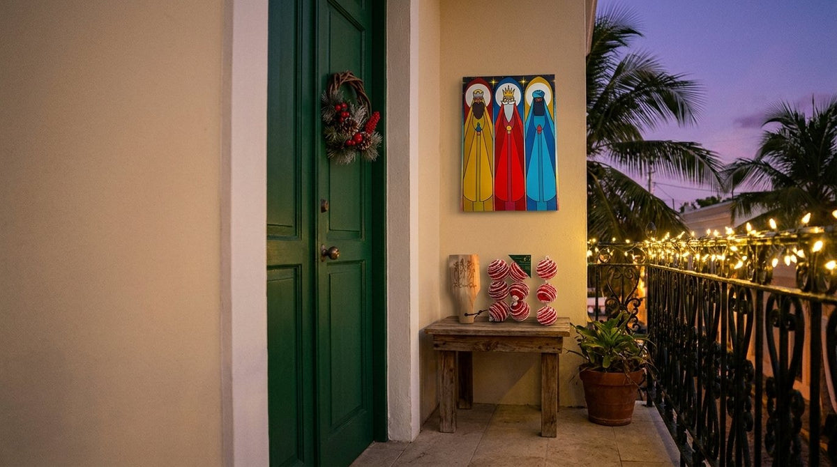 Entrada de una casa boricua decorada para Navidad con corona en la puerta, cuadro de los Tres Reyes Magos y esferas navideñas junto a un balcón con luces