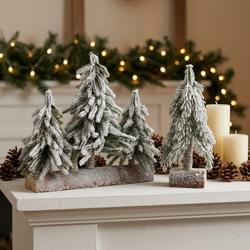 Árboles de Navidad nevados sobre tronco y sobre base cuadrada